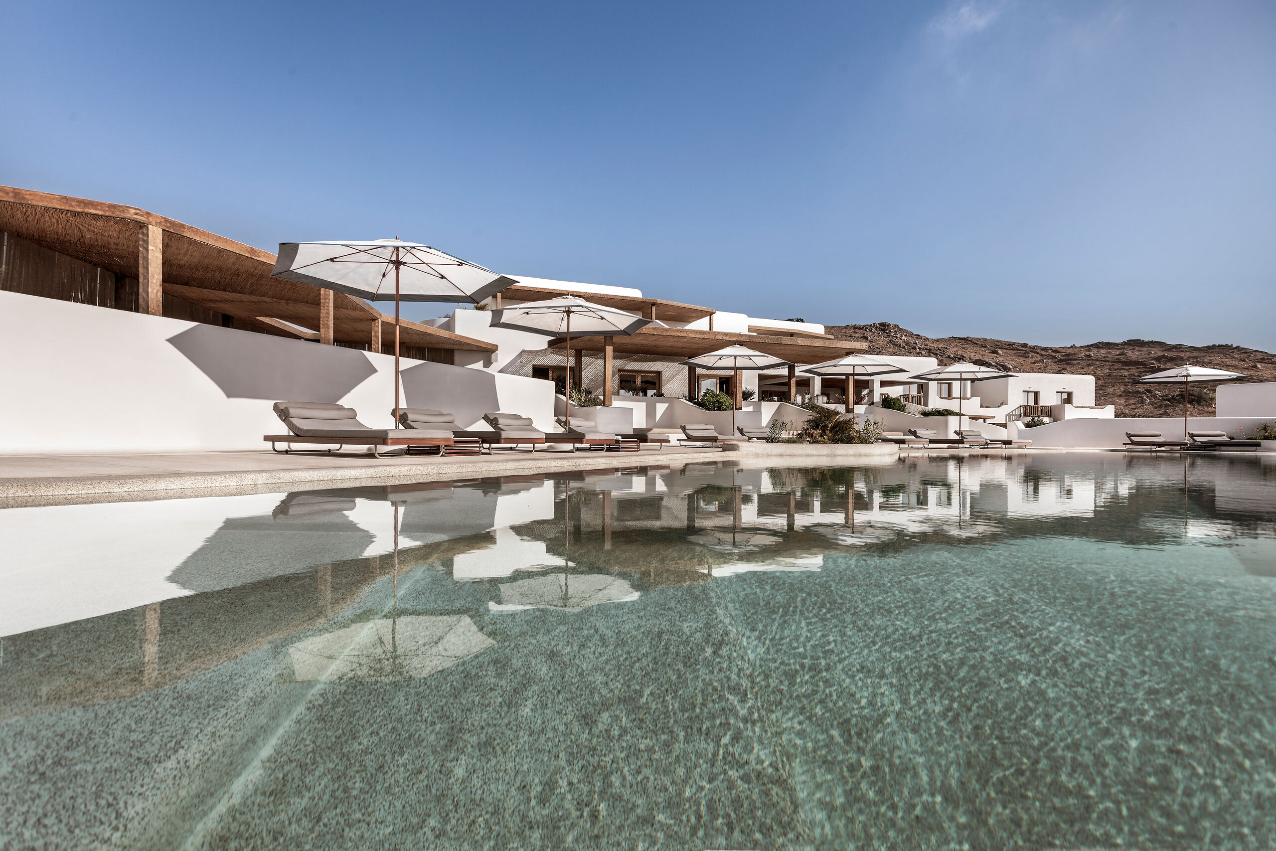 Center pole parasols beside a resort pool